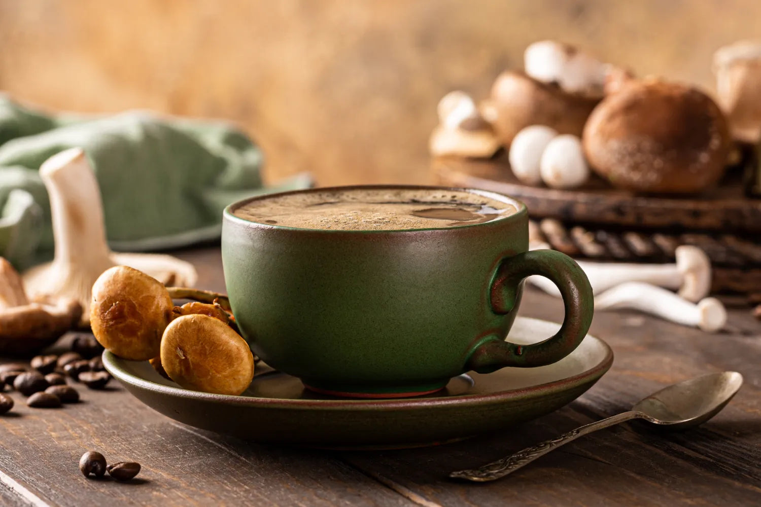 Green ceramic cup of mushroom coffee on saucer with fresh mushrooms and coffee beans on a rustic wooden table
