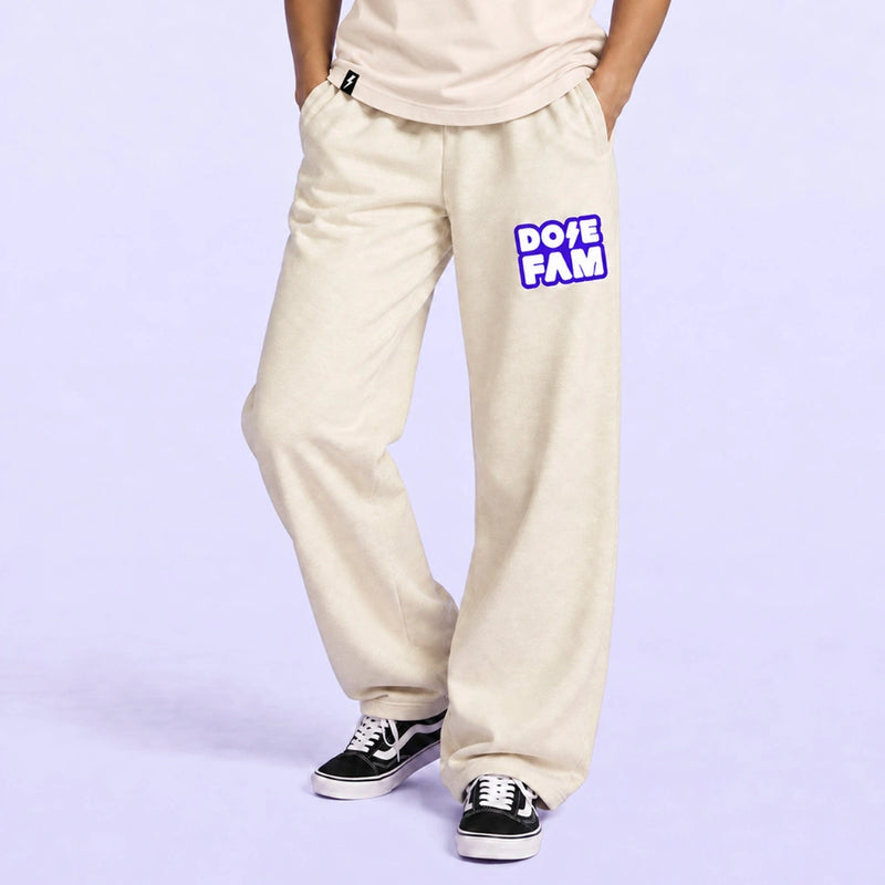 Cream wide leg sweatpants with a purple and white DOPE FAM logo, styled with black sneakers against a lavender background