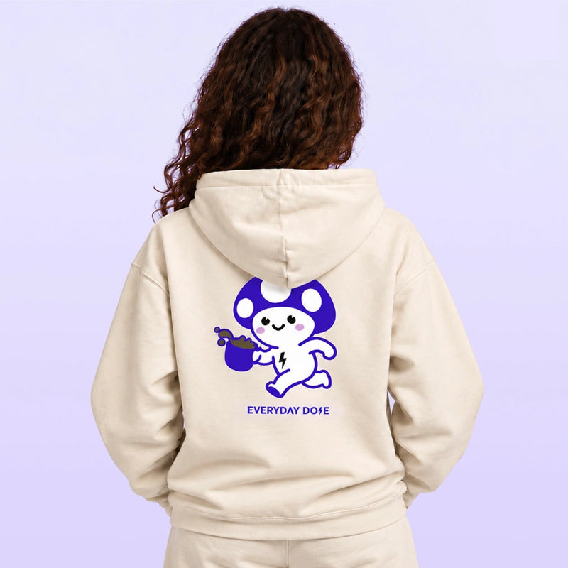 Back view of a woman wearing a cream hoodie with a purple and white cartoon graphic and Everyday Dope text against a lavender background