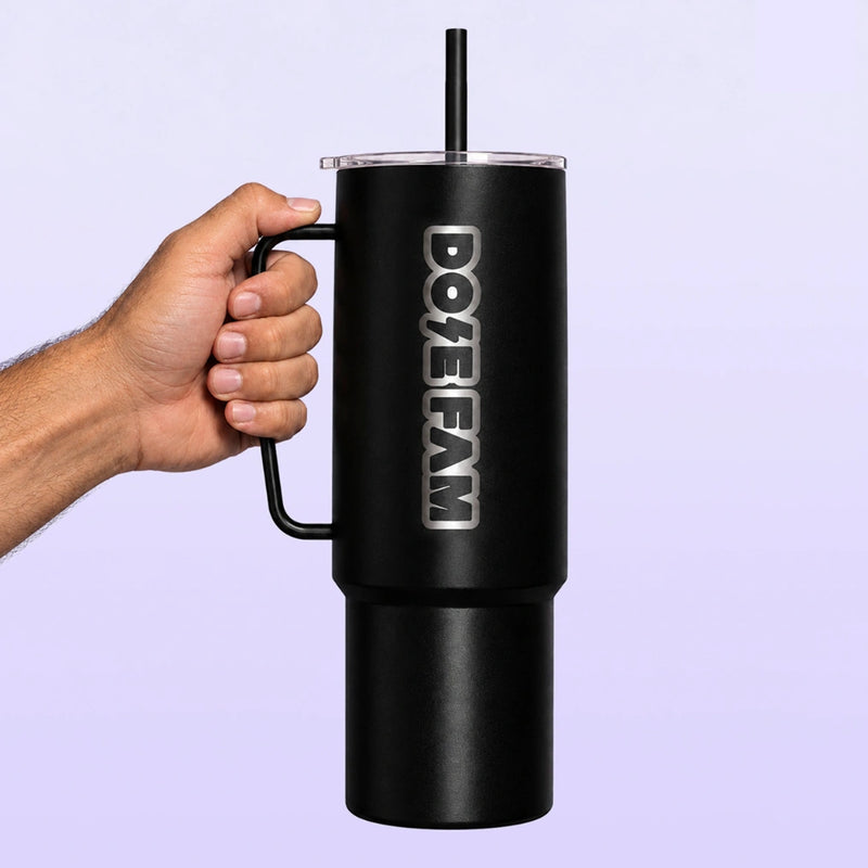 Black insulated tumbler with handle, straw, and vertical DOPE FAM logo held against a light lavender background