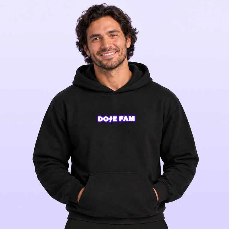 Smiling man wearing a black pullover hoodie with a purple and white DOPE FAM chest logo against a lavender background