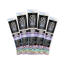 Five medium roast coffee stick packs with dark packaging and colorful accents arranged in a fan shape with coffee bean illustrations at the bottom