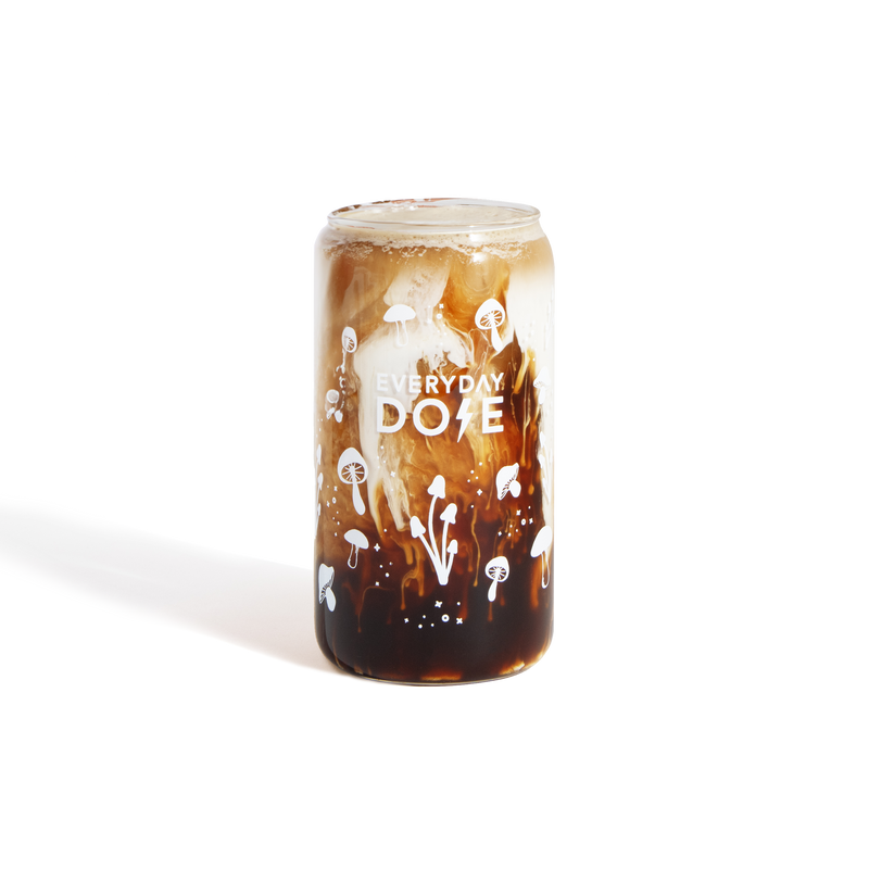 Mushroom Glass featuring creamy white foam swirled into dark coffee drink in a clear glass with artistic dope branding