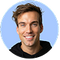 Founder of Everyday Dose, Jack Savage, smiling in front of a blue background
